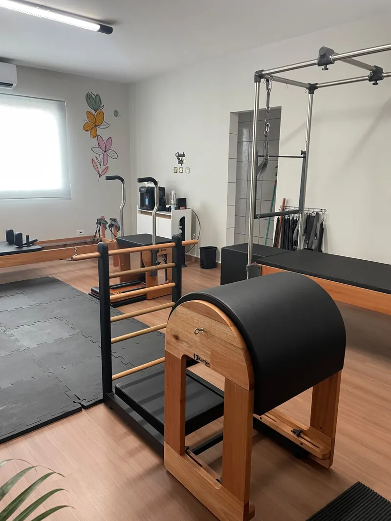Ladder Barrel de madeira em primeiro plano, com o Chair, o Reformer e o Cadillac ao fundo
